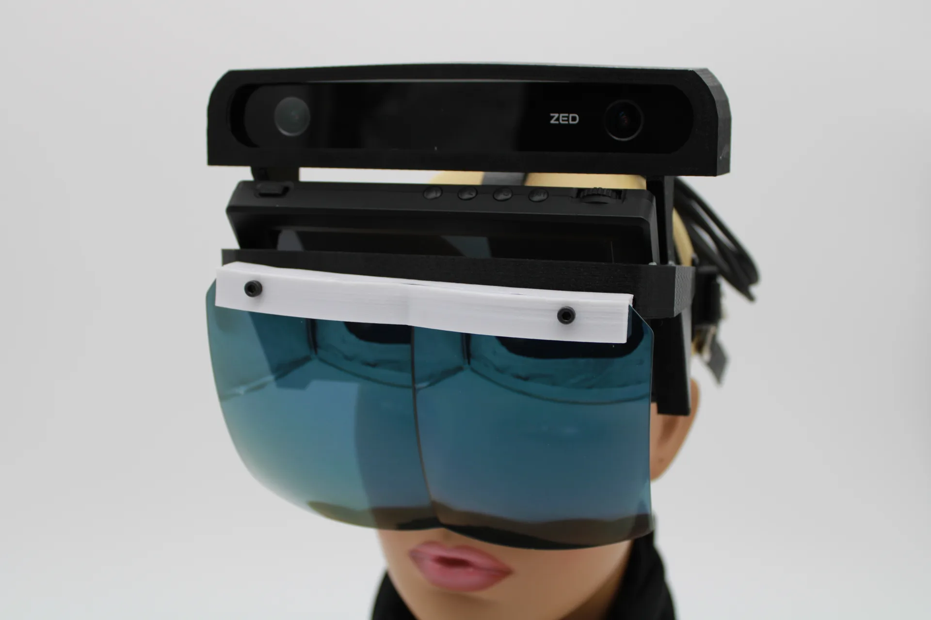 Front view of the same build: the ZED camera across the top, black housing and a wide blue-tinted visor covering the mannequin's eyes.