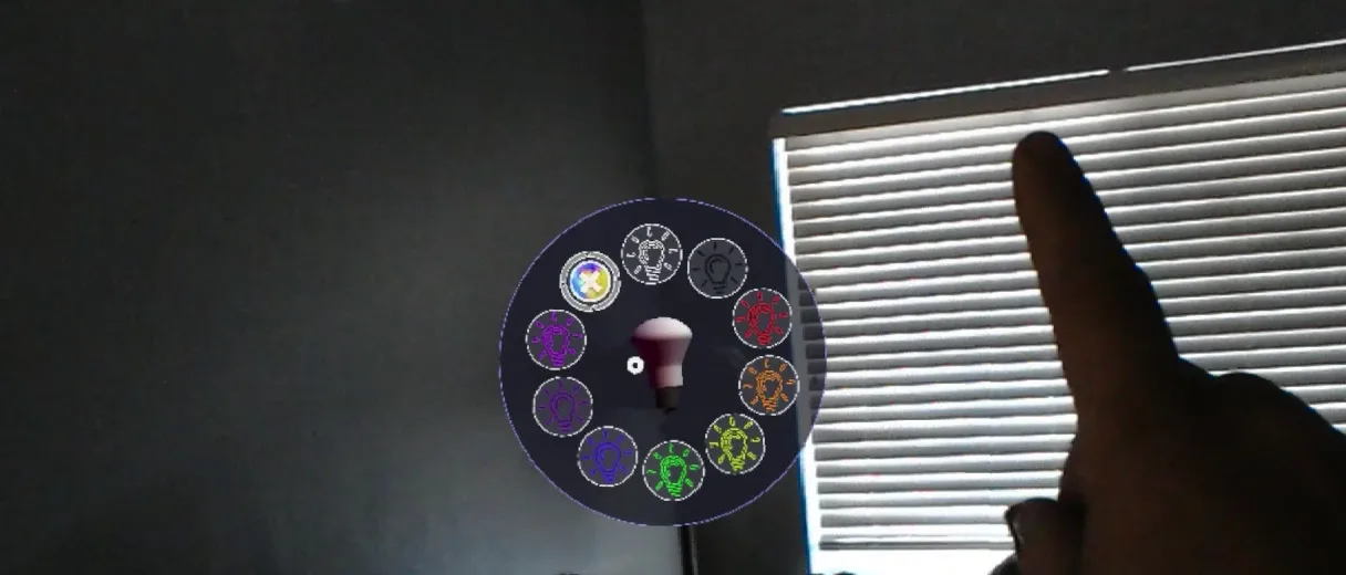 A raised finger beside a floating round menu with a bulb icon in its center, in front of window blinds.
