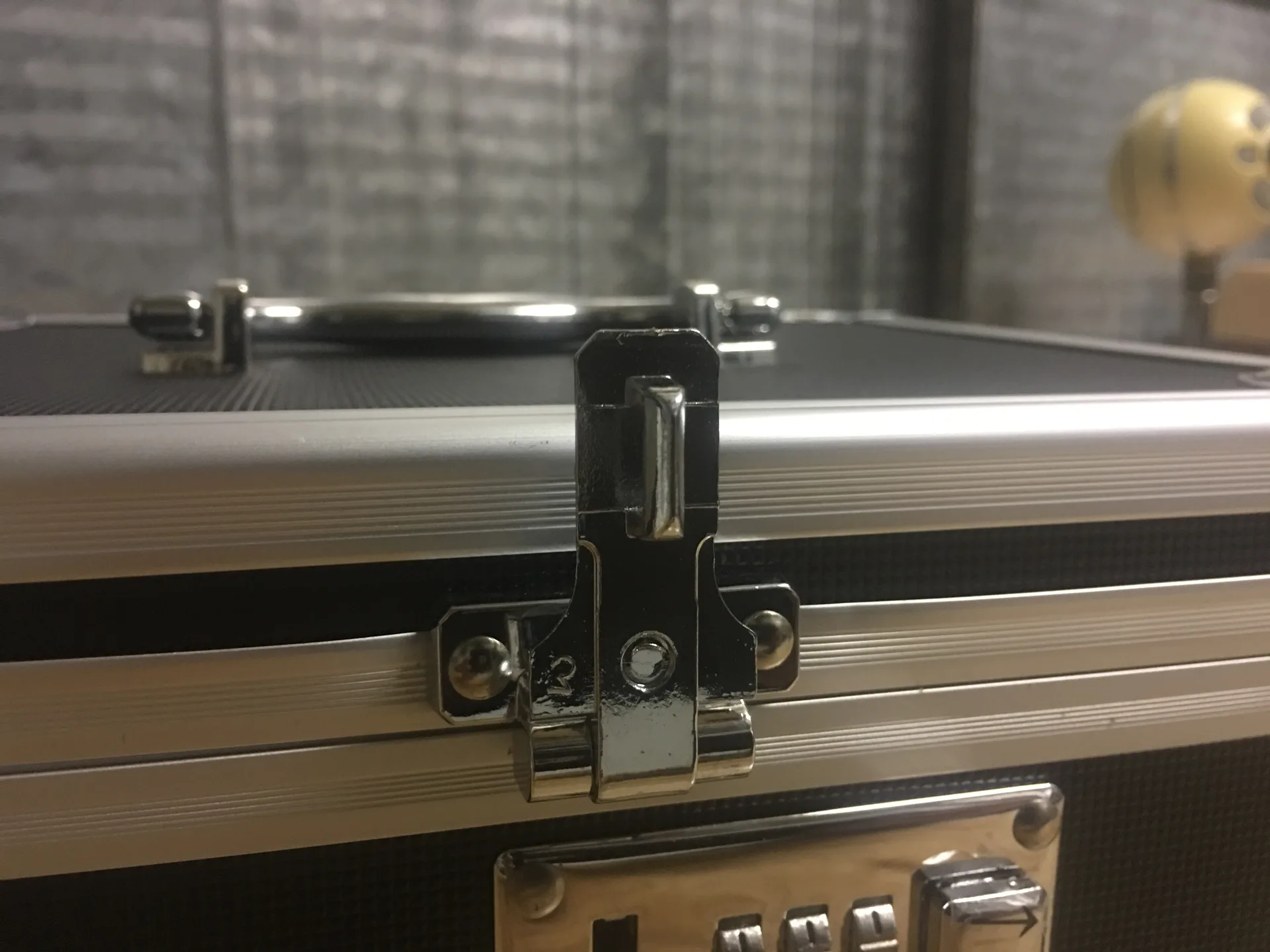 Close-up of the case's chrome latch and combination lock.